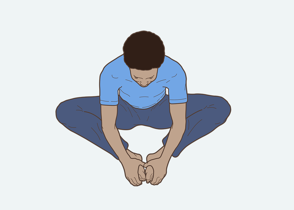 Person in a seated position, placing the soles of their feet together and holding them with their hands.